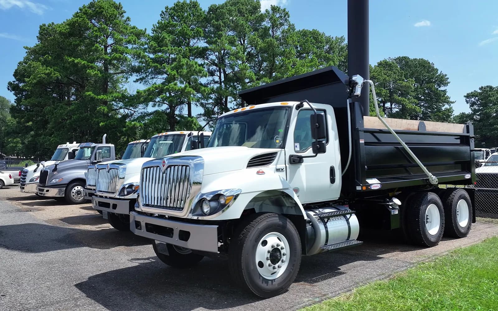 White tandem-axle International HV dump truck with a Ledwell 12 to 14 yard steel dump body, front three-quarter view