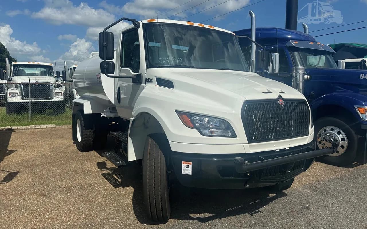 White International MV water truck with a Ledwell water tank, front three-quarter view on a dealer lot
