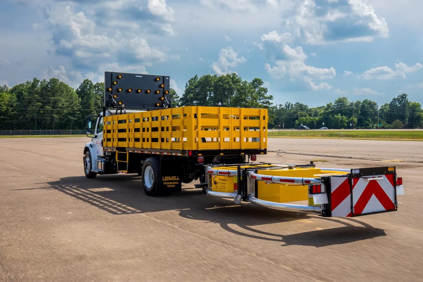 Ledwell attenuator truck with yellow stake sides and a rear-mounted crash cushion