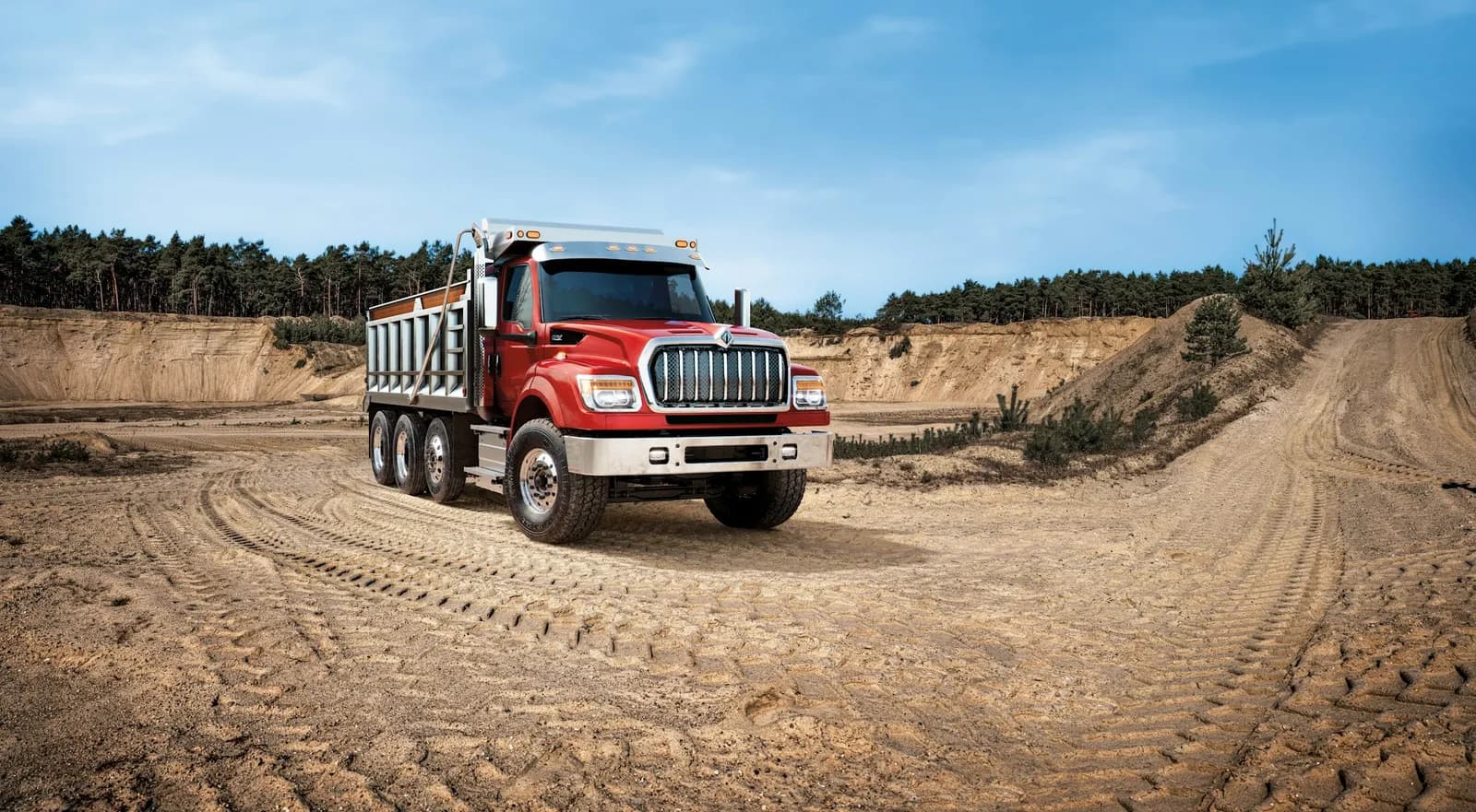 Red International HV Series dump truck loading in a gravel pit