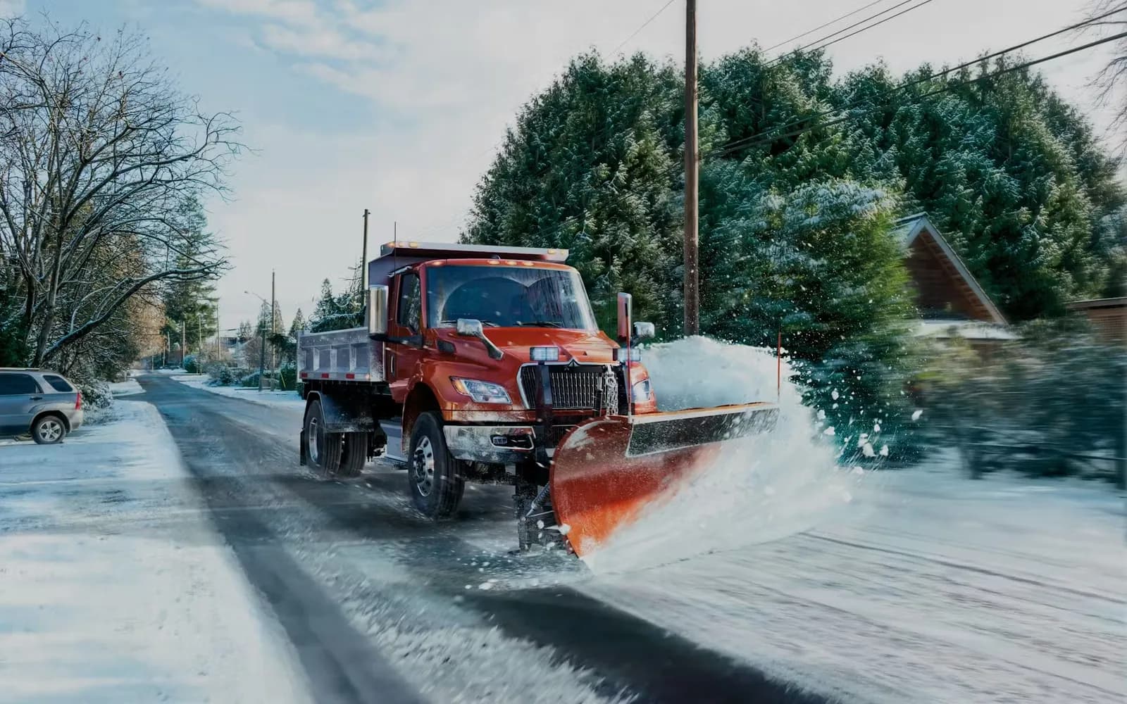 MV Series truck with snow plow clearing a road