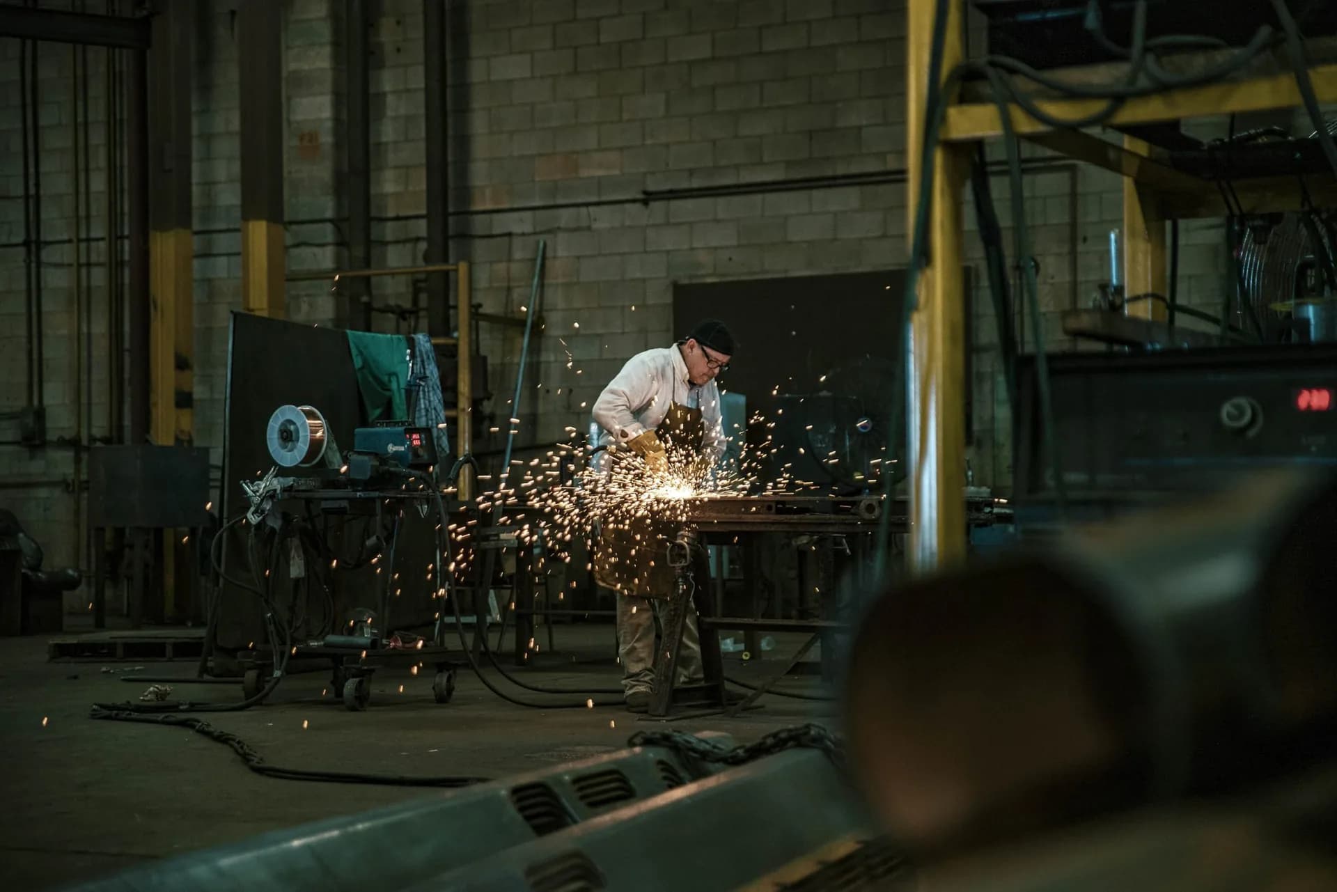 Worker grinding steel in the Ledwell tank shop