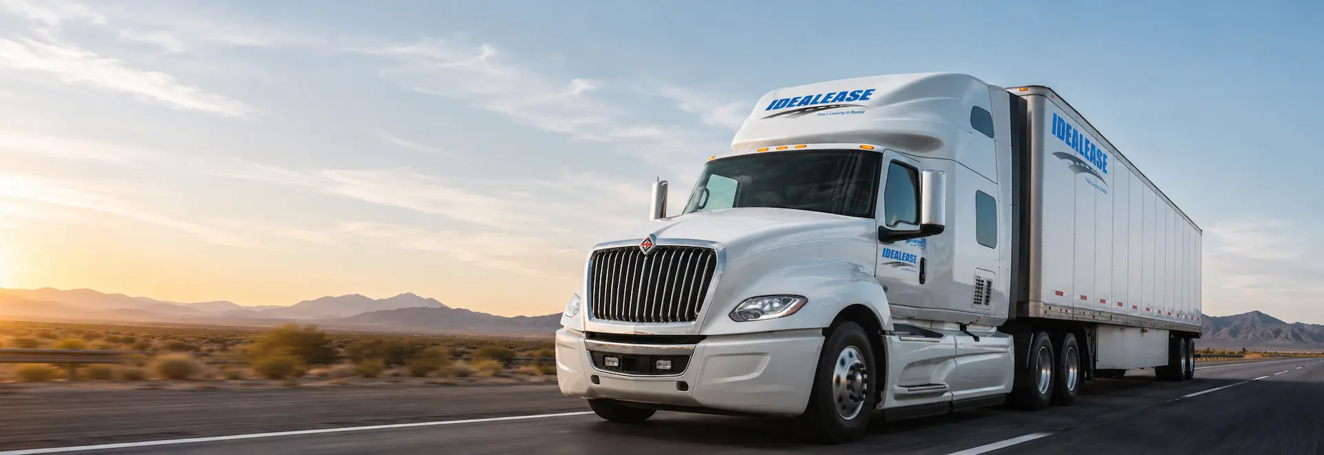 Idealease-branded International tractor-trailer on the highway at sunset